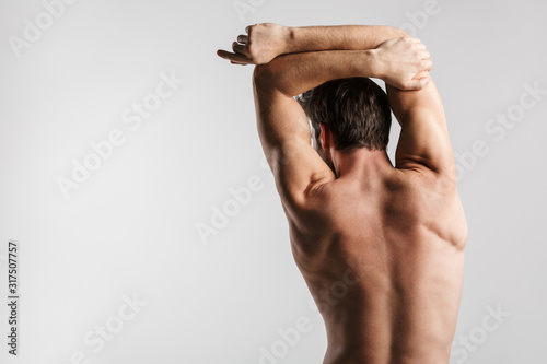 Image from back of shirtless man doing exercise while working out