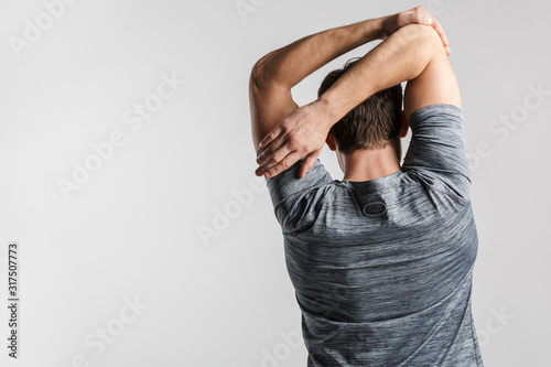 Image from back of young athletic man doing exercise while working out photo