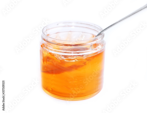sweet yellow honey food in glass jar with spoon isolated on white background