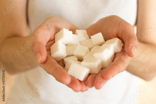 handfull of white sugar cubes on white background
