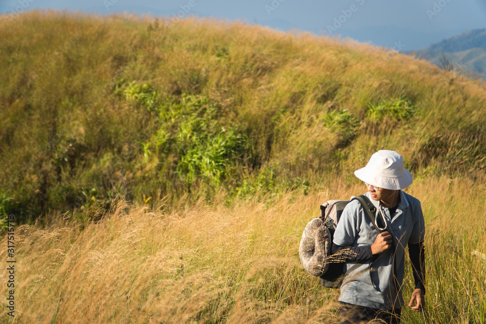 A male hiker carrying backpack looking at mountain