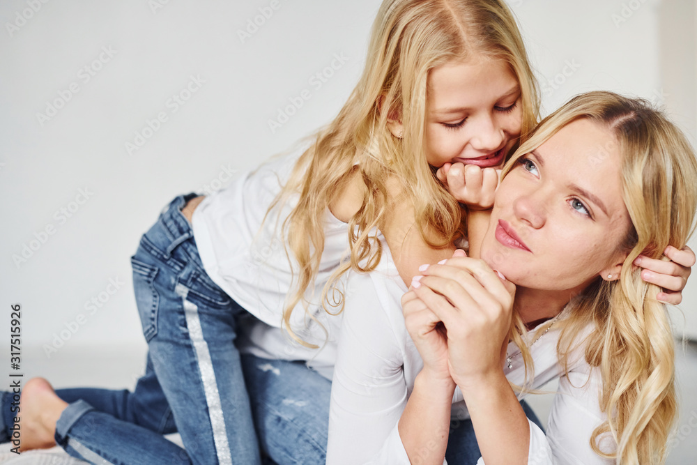 Mother with her daughter together in the studio with white background Mother with her daughter together in the studio with white background