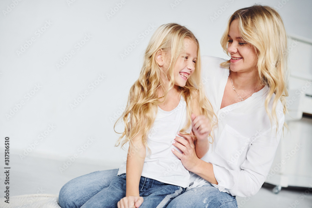Closeness of the people. Mother with her daughter together in the studio with white background