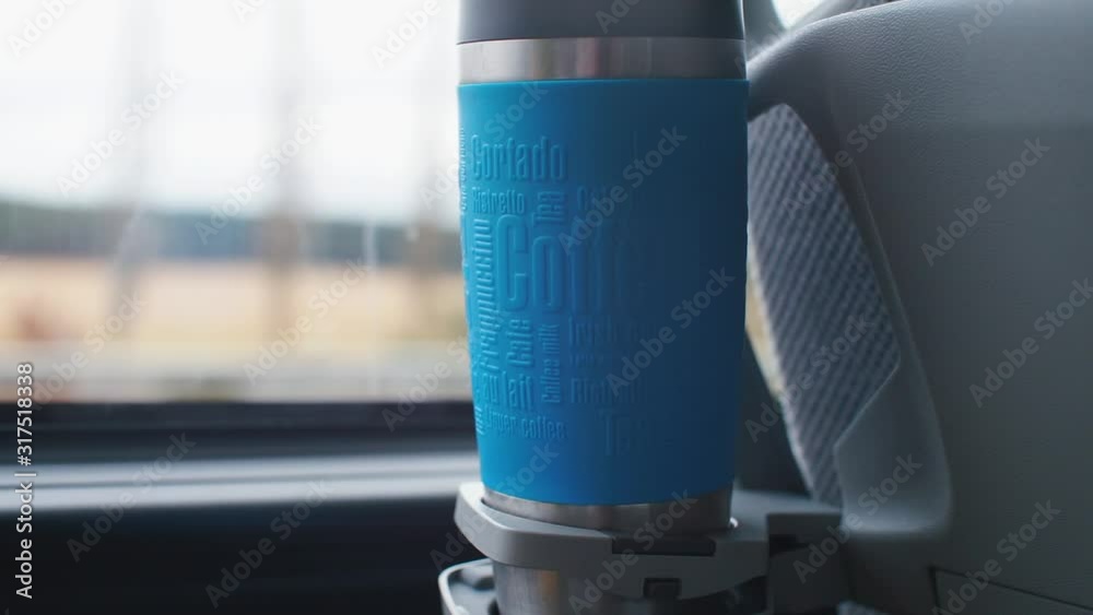 Thermos with a hot drink is in the cup holder in a tourist bus. Thermos with a hot drink is in the cup holder in a tourist bus.
