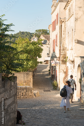Tourist walking in the street in medieval village of Les Baux de Provence. © acongar