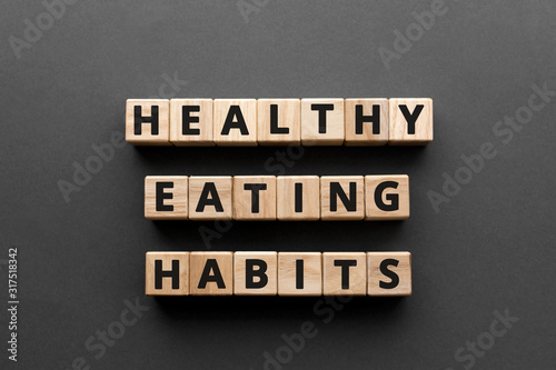 Healthy Eating Habits - words from wooden blocks with letters, healthy eating habits concept, top view gray background