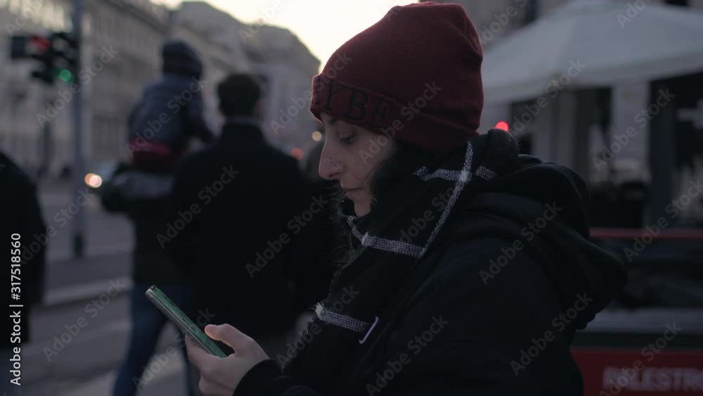 Adult woman outdoor at dusk smoking cigarette using smartphone – unhealthy, addiction, pensive concept