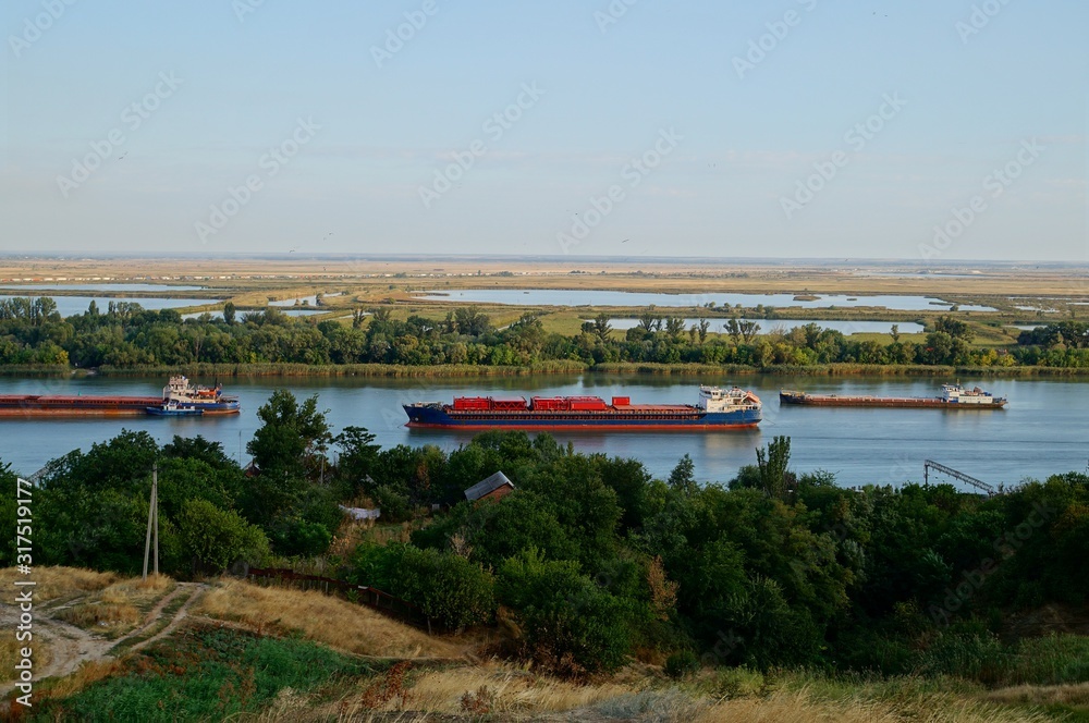 A transport ship is floating on the river. Summer natural landscape.