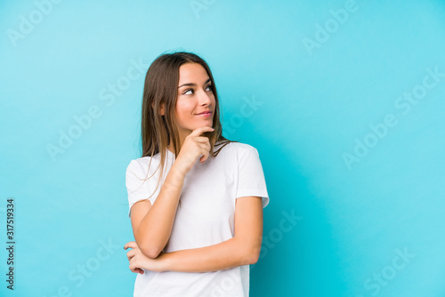 Young caucasian woman isolated looking sideways with doubtful and skeptical expression.