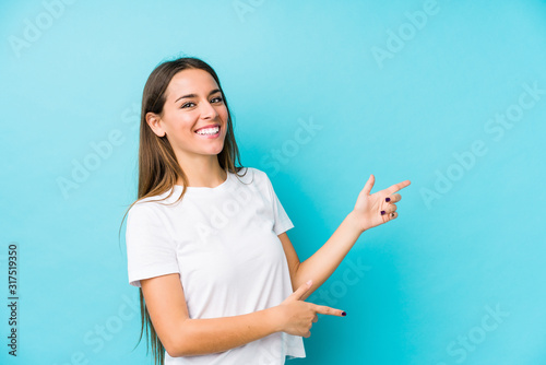 Young caucasian woman  isolated excited pointing with forefingers away.