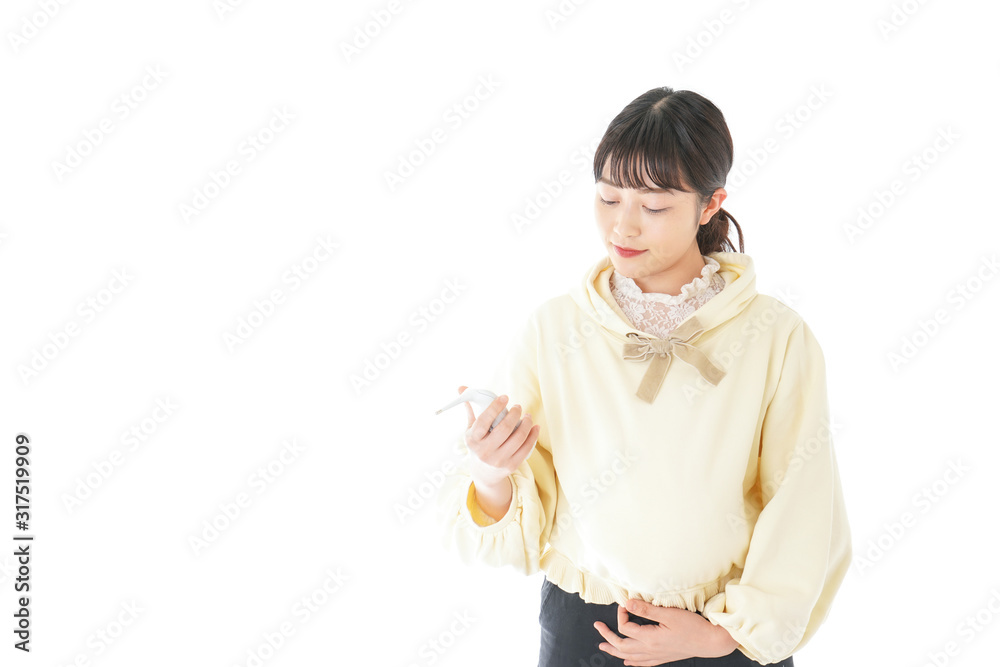 検温をする若い妊婦の女性 検温をする若い妊婦の女性