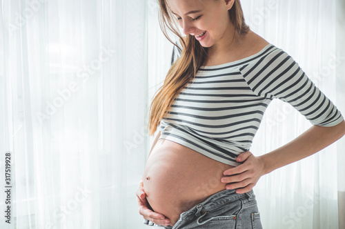 Happy pregnant woman with big belly by the window. Concepts of pregnancy and family Free Download Happy pregnant woman with big belly by the window. Concepts of pregnancy and family - GFXLoad
