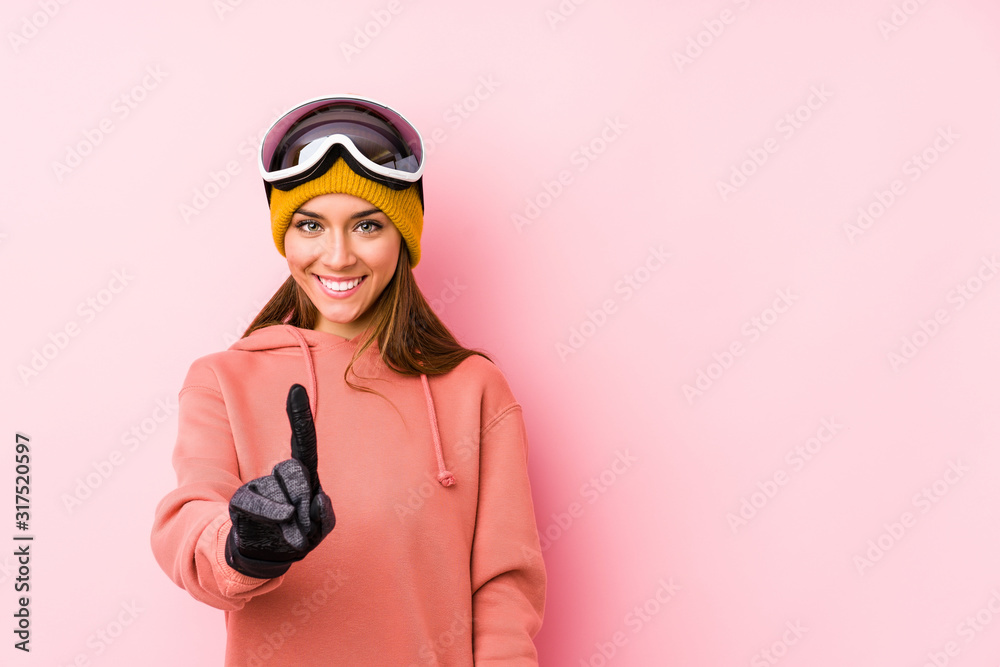 Young caucasian woman wearing a ski clothes isolated showing number one with finger.