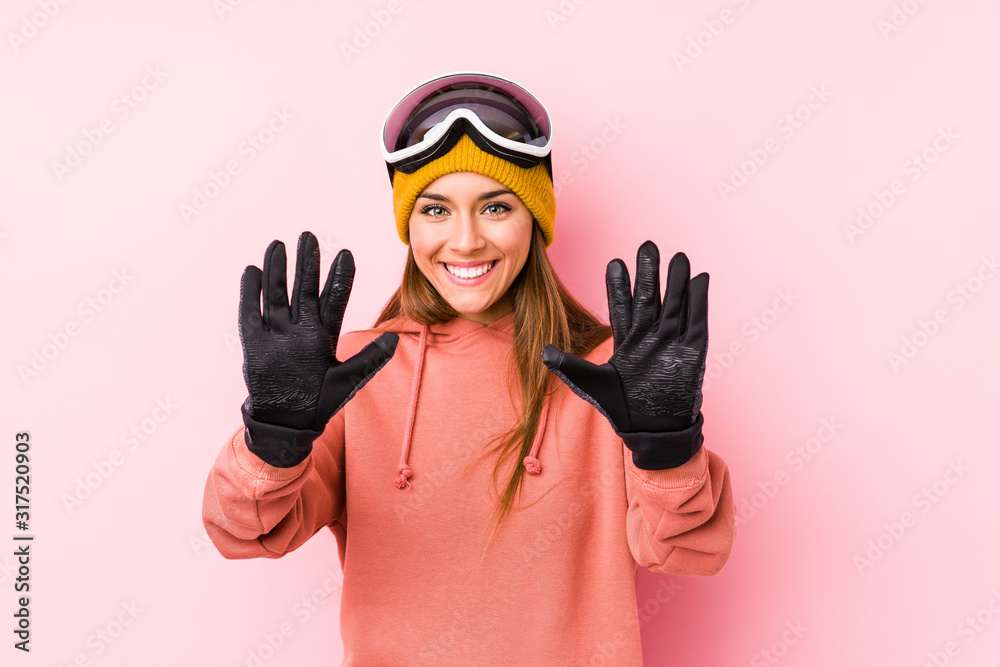Young caucasian woman wearing a ski clothes isolated showing number ten with hands. Young caucasian woman wearing a ski clothes isolated showing number ten with hands.