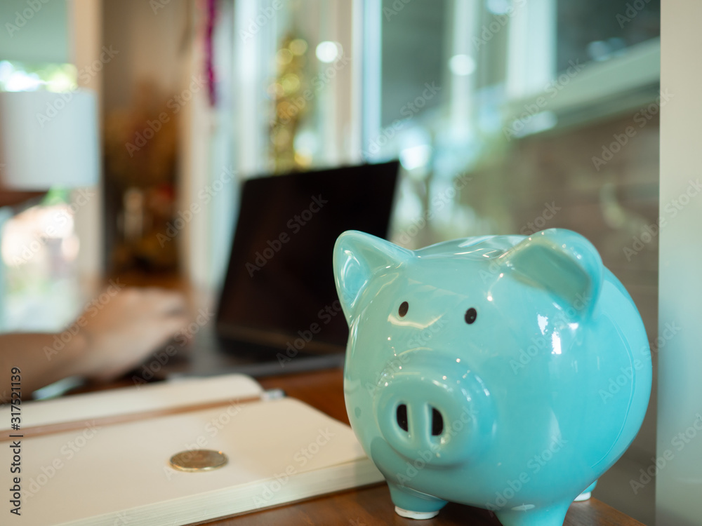 Blue piggy bank on the table with laptop and a cup of coffee. Blue piggy bank on the table with laptop and a cup of coffee.