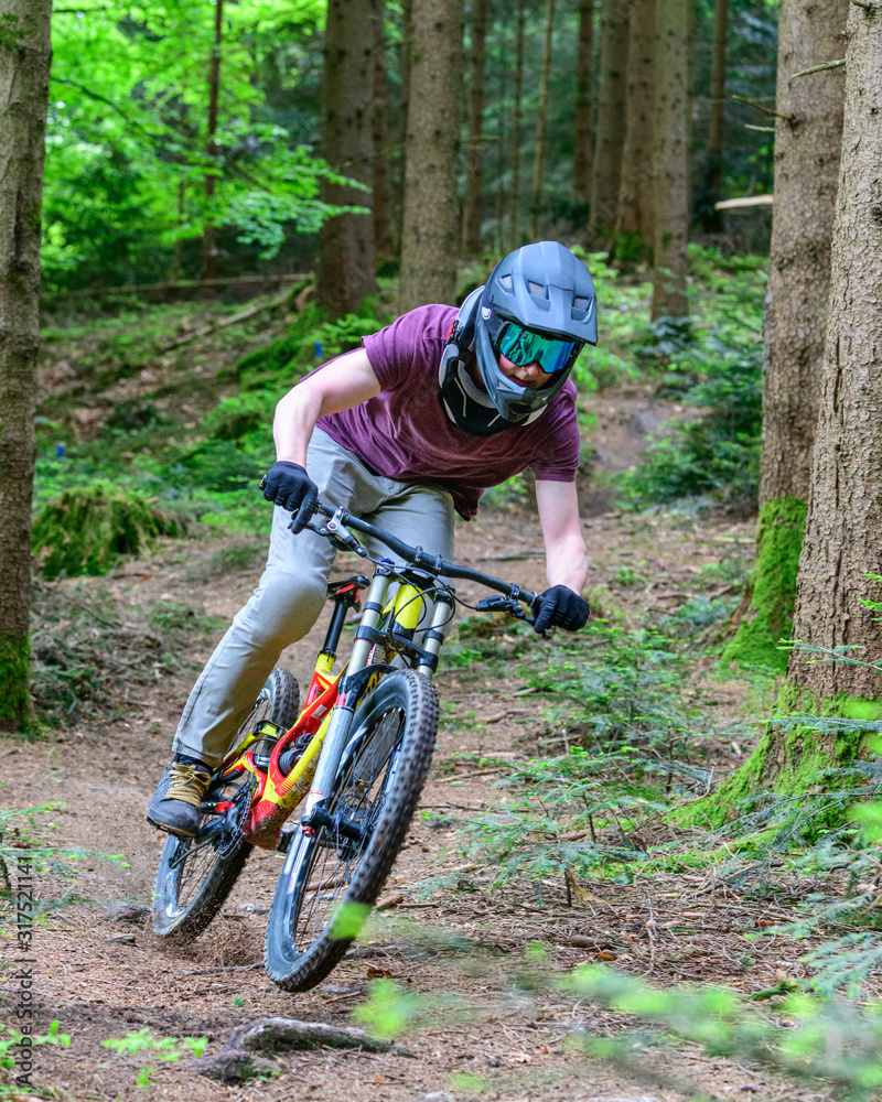 Fototapeta premium Verwegene Mountainbiker beim Downhill auf Wald-Trails