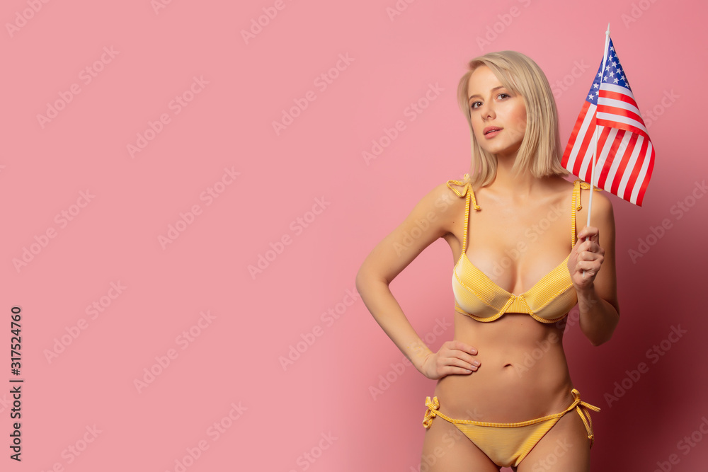Beautiful blonde woman in yellow bikini with USA flag - obrazy, fototapety, plakaty 