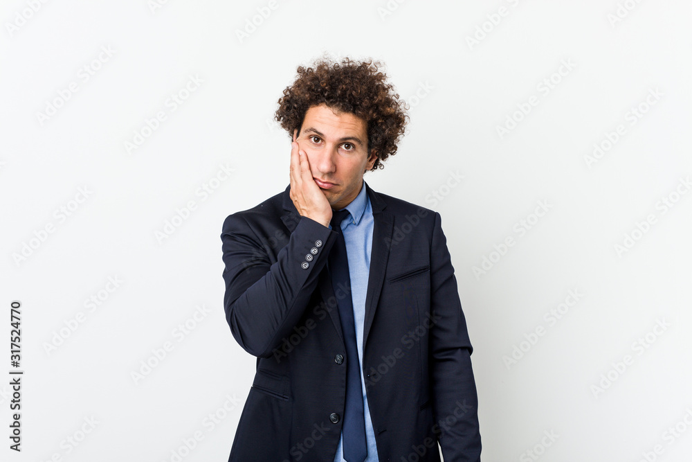 Young business curly man against white background who is bored, fatigued and need a relax day. Young business curly man against white background who is bored, fatigued and need a relax day.