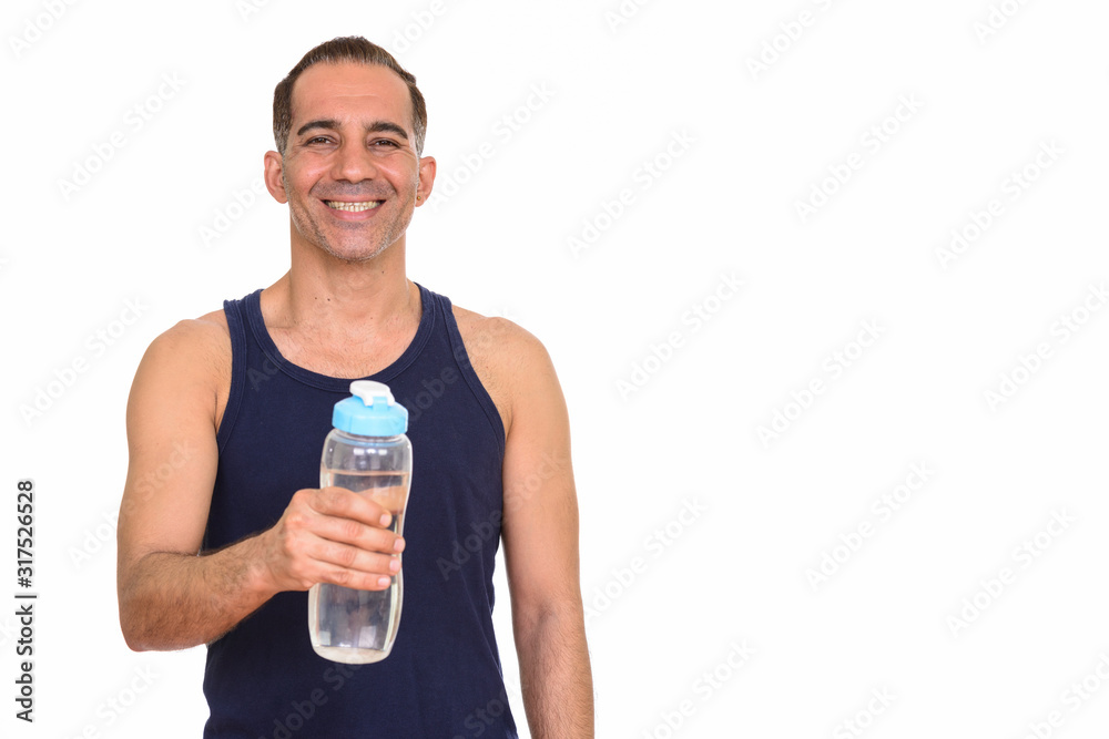 Mature happy Persian man holding water bottle ready for gym Mature happy Persian man holding water bottle ready for gym