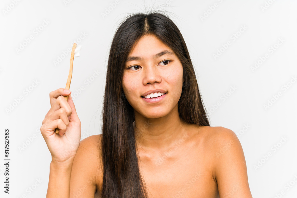 Young chinese woman holding a teeth brush isolated smiling confident with crossed arms. Young chinese woman holding a teeth brush isolated smiling confident with crossed arms.