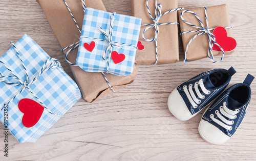 Greeting children card. Blue sneakers and gift boxeswith red heart. Top view photo