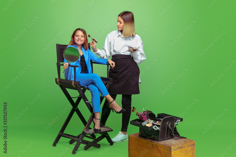 Obraz premium First client. Little girl dreaming about profession of make up artist. Childhood, planning, education, dream concept. Wants to become successful employee in fashion and style industry, visage artist.