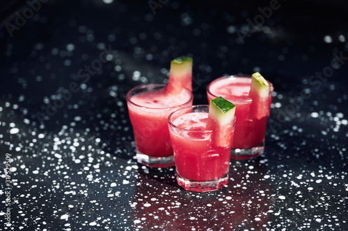 Summer cocktail with watermelon on black metal surface. photo