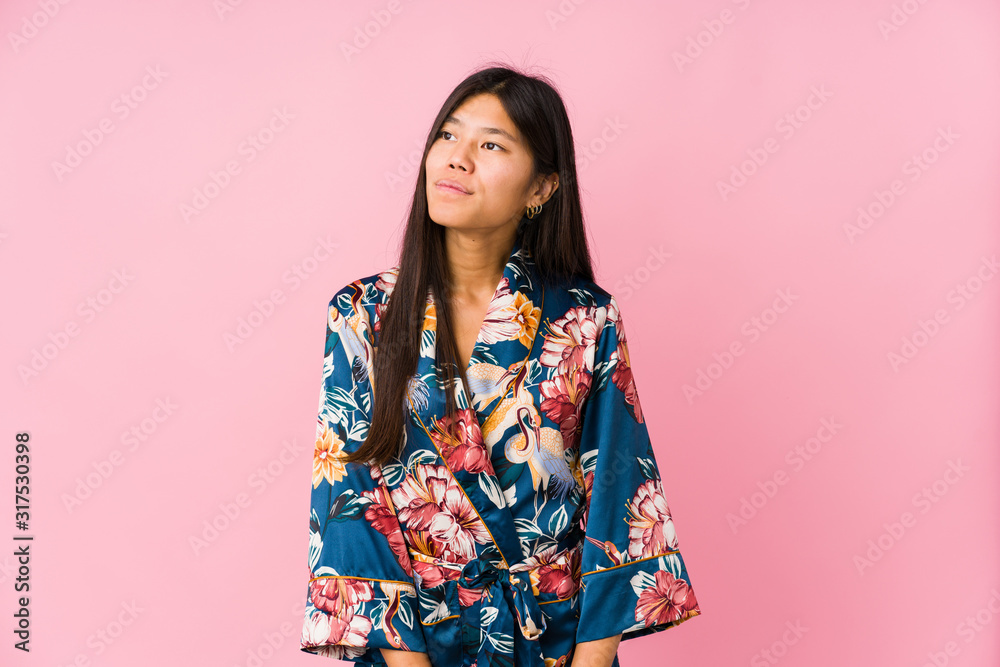 Young asian woman wearing a kimono pajamas dreaming of achieving goals and purposes Young asian woman wearing a kimono pajamas dreaming of achieving goals and purposes