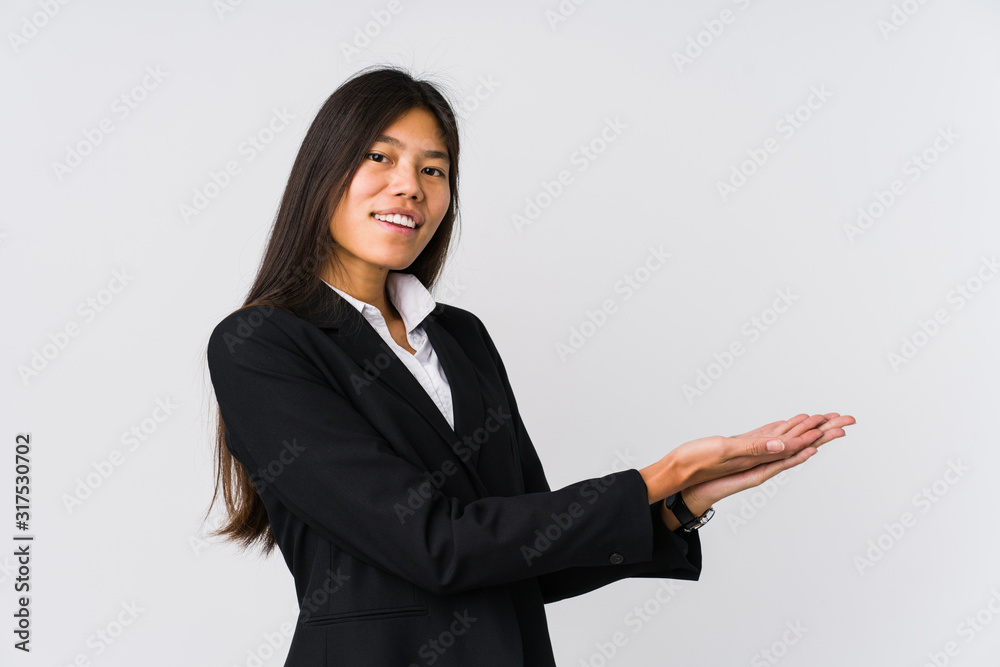 Young asian business woman holding a copy space on a palm. Young asian business woman holding a copy space on a palm.