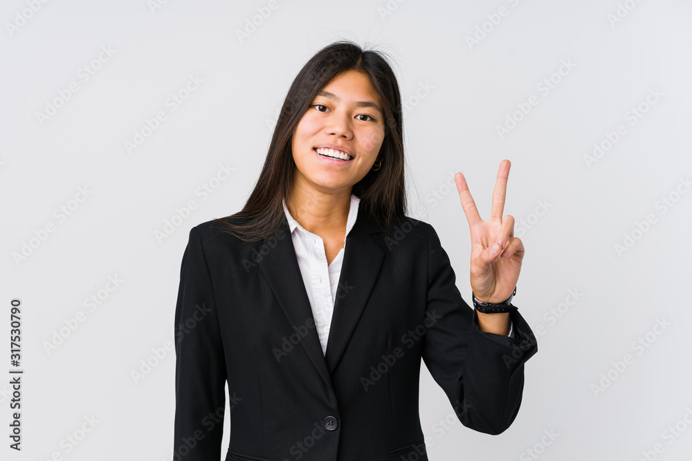 Young asian business woman showing victory sign and smiling broadly. Young asian business woman showing victory sign and smiling broadly.