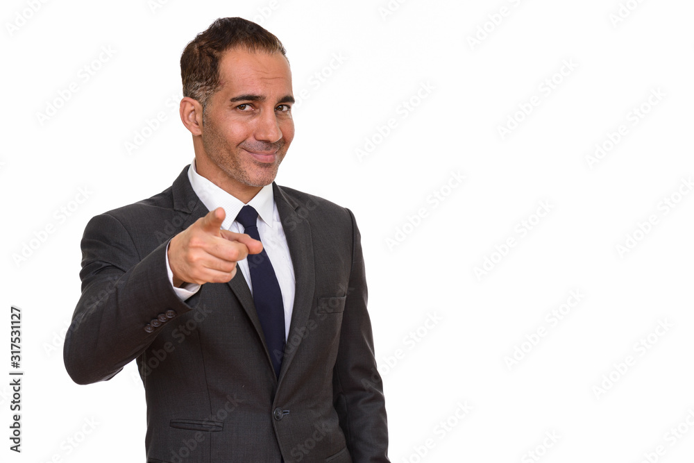 Mature happy Persian businessman pointing finger at camera Mature happy Persian businessman pointing finger at camera