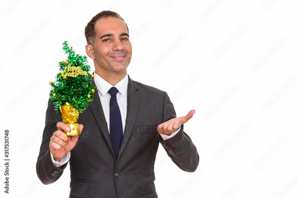 Mature happy Persian businessman holding Happy New Year tree Mature happy Persian businessman holding Happy New Year tree