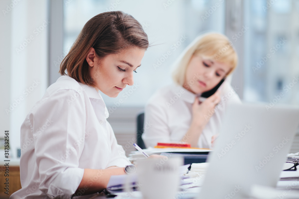 Two women in office working on a computer Two women in office working on a computer