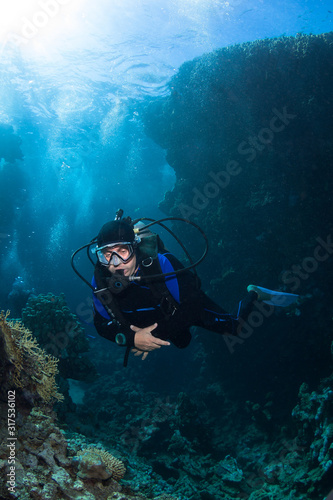 Scuba Diver explores coral reef .