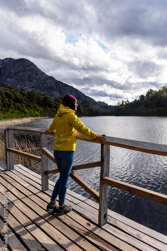 Reflection of a traveler with a yellow jacket on a viewpoint at the Hidden Lake in Bariloche, Argentina