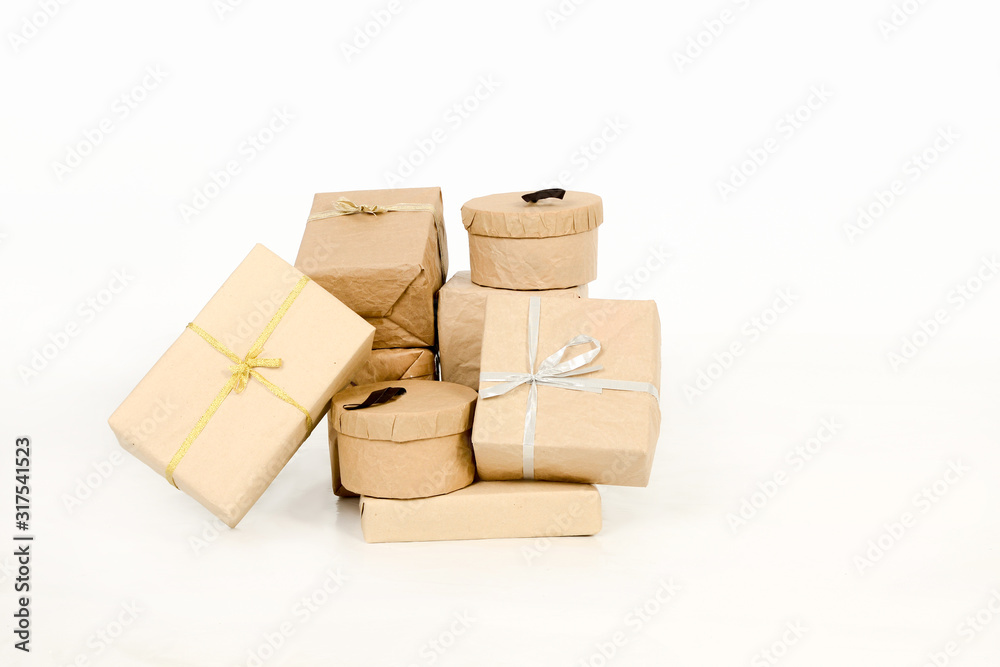 Obraz premium Varios regalos, paquetes envueltos en papel kraft marrón con lazos aislados sobre fondo blanco