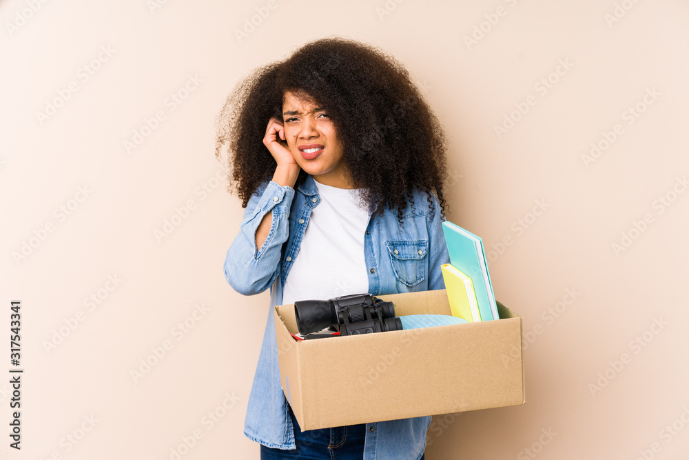Young afro woman moving home isolated Young afro woman covering ears with hands. Young afro woman moving home isolated Young afro woman covering ears with hands.
