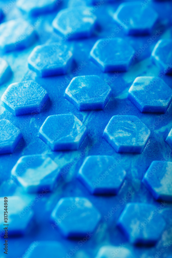 Abstract texture of a blue massage roller in the form of blue hexagonal cells. The entire screen as the background. Abstract texture of a blue massage roller in the form of blue hexagonal cells. The entire screen as the background.