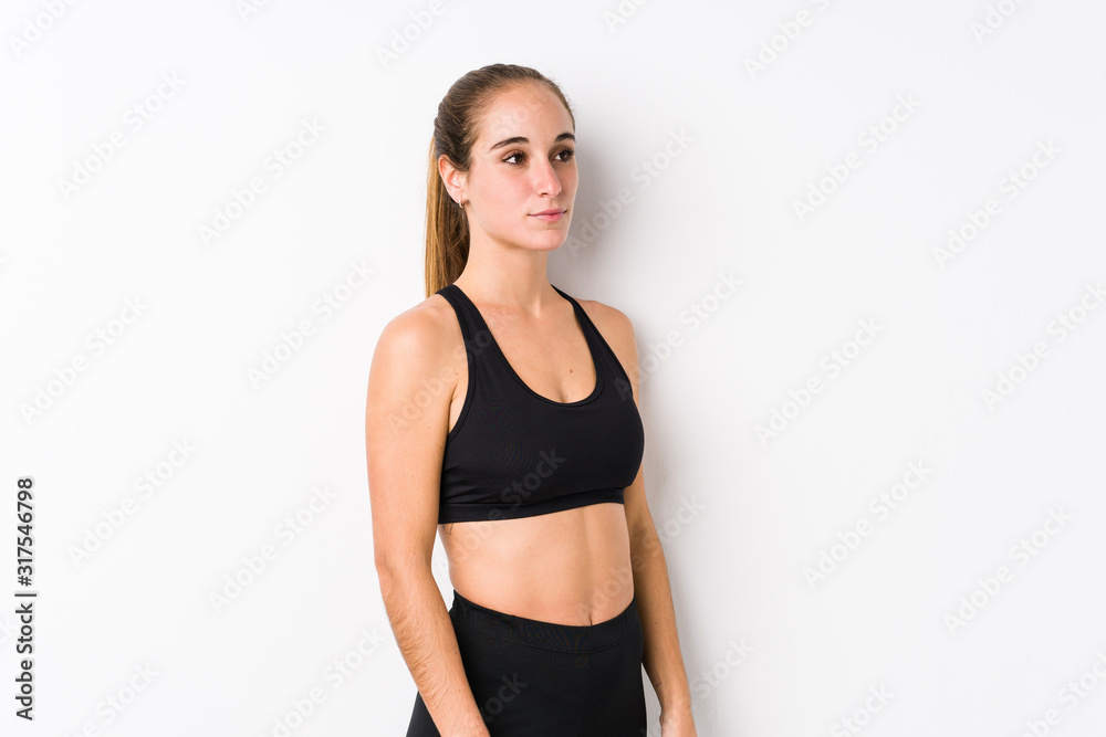 Young caucasian fitness woman posing in a white background gazing left, sideways pose. Young caucasian fitness woman posing in a white background gazing left, sideways pose.