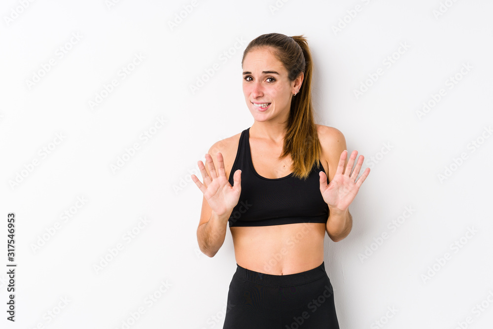 Young caucasian fitness woman posing in a white background rejecting someone showing a gesture of disgust. Young caucasian fitness woman posing in a white background rejecting someone showing a gesture of disgust.