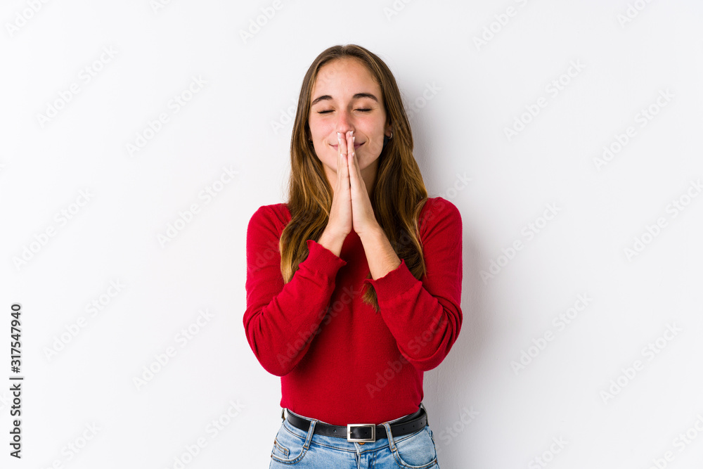 Young caucasian woman posing isolated holding hands in pray near mouth, feels confident. Young caucasian woman posing isolated holding hands in pray near mouth, feels confident.