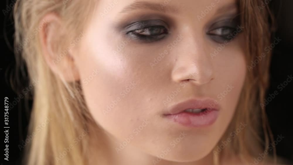 Close-up portrait of a girl on a black isolated background. Blonde with wet hair posing in the studio. Close-up portrait of a girl on a black isolated background. Blonde with wet hair posing in the studio.