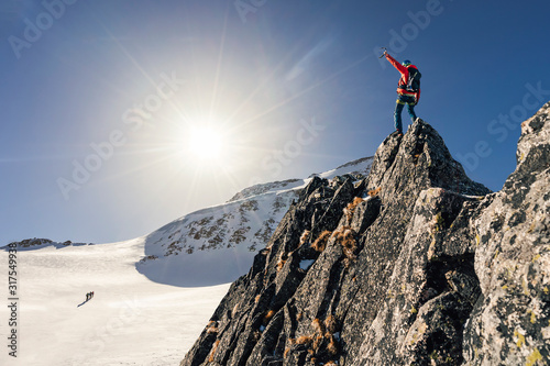 Foto Climber or alpinist at the top of a mountain