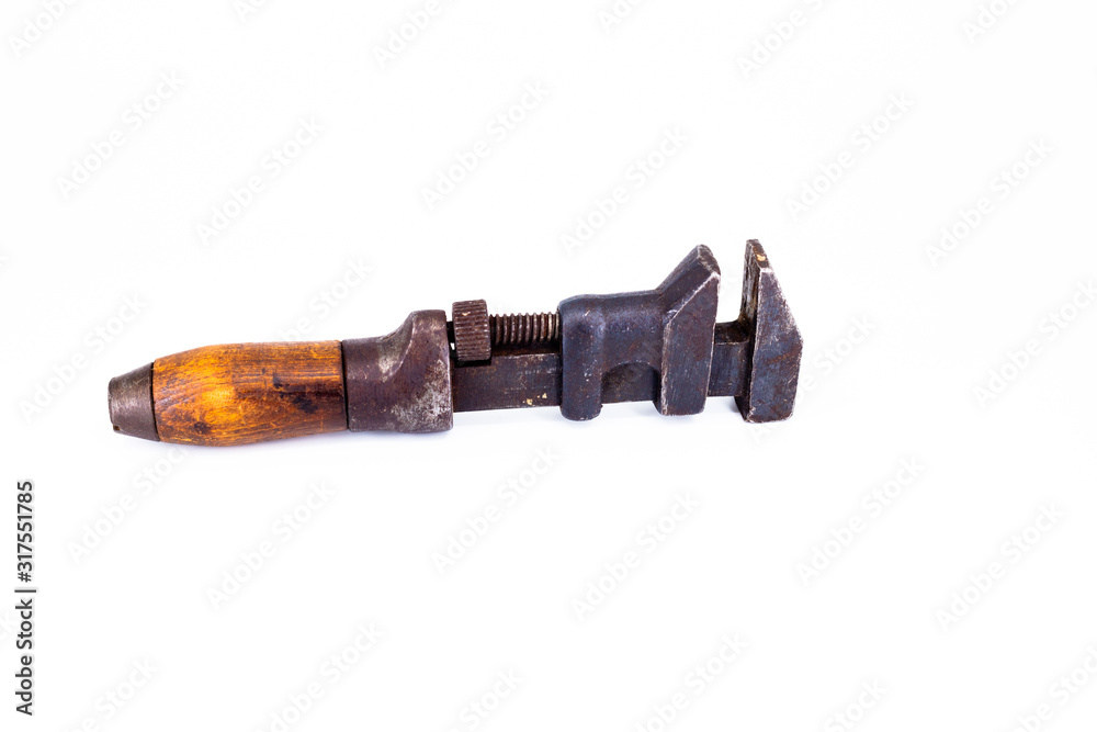 Old rusty plumbers monkey wrench with wooden handle