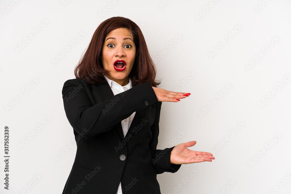 Middle age latin business woman isolated shocked and amazed holding a copy space between hands.