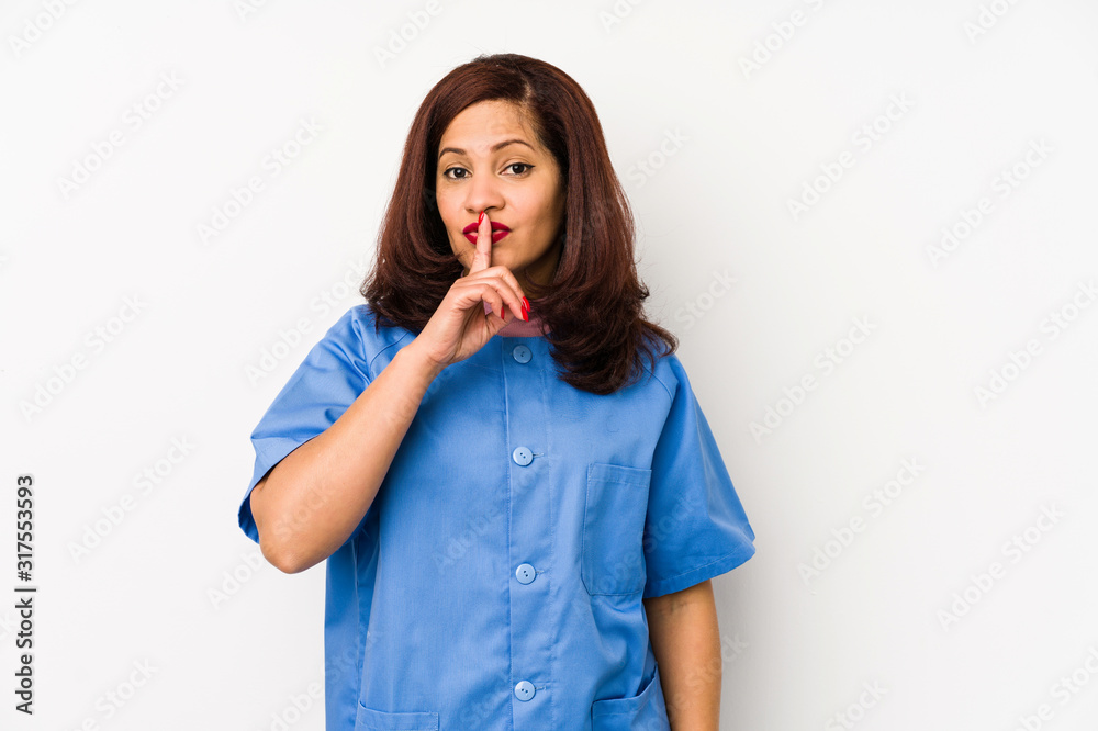 Middle age latin nurse woman isolated çkeeping a secret or asking for silence. Middle age latin nurse woman isolated çkeeping a secret or asking for silence.