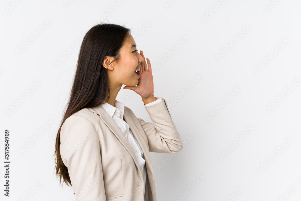 Young chinese business woman isolated shouting and holding palm near opened mouth. Young chinese business woman isolated shouting and holding palm near opened mouth.