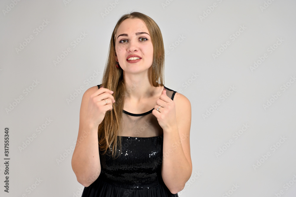 Universal concept horizontal portrait of a woman on a white background. A photo of a pretty smiling girl with long hair and excellent make-up in a black dress stands in different poses. Universal concept horizontal portrait of a woman on a white background. A photo of a pretty smiling girl with long hair and excellent make-up in a black dress stands in different poses.