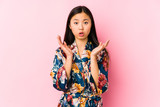 Young chinese woman wearing a kimono pajama isolated surprised and shocked.