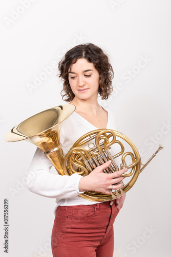 Porträt einer jungen Hornistin eines Philharmonischen Orchesters mit ihrem Instrument